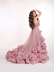Beautiful Lady in luxury lush pink dress. Fashion brunette woman in gorgeous long gown posing...