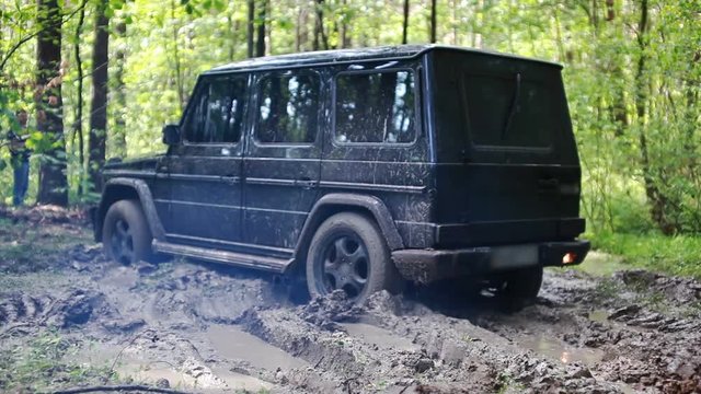 Black SUV got stuck in the mud in the forest, off-road