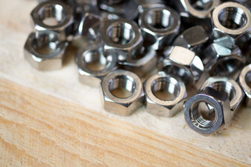 Steel nuts on wooden background