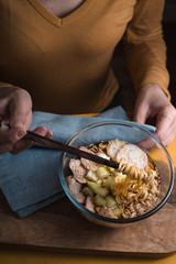 Woman eating soup with ramen noodles with chicken and celery