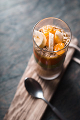 Smoothies with slices of banana, mandarin on a rustic pedestal