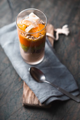 Healthy smoothie with banana, pampkin, avocado and flax seeds in a glass bottles on a rustic background