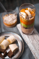 Smoothies and banana slices and biscuit on a tin plate