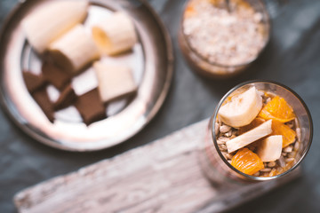 Smoothies and banana slices and biscuit on a tin plate