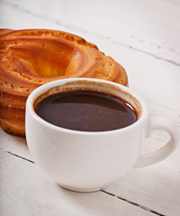 Cup of coffee and delicious baked cookies on old wooden background.