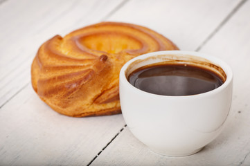 Cup of coffee and delicious baked cookies on old wooden background.