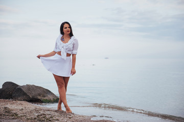 Fototapeta na wymiar woman in a white shirt and skirt dancing barefoot