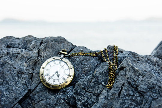 vintage golden pocket watch on rock