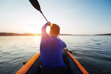 Foto op Canvas man floating on lake in a kayak at fantastic sunset. © standret