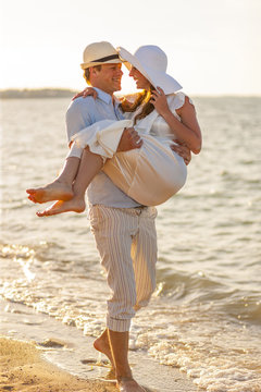 Groom carrying bride over beach, Dalmatia, Croatia