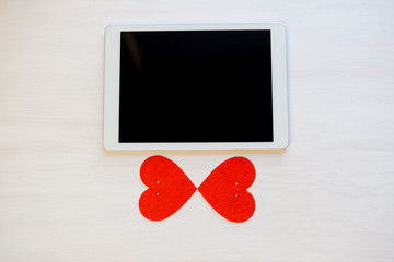 Love is in the Air! Tablet Pc computer with blank screen on hearts background. Valentine day concept symbol design