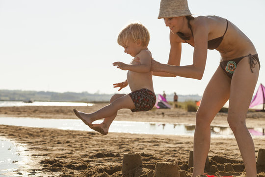 Croatia, Dalmatia, Mother And Son On Sandy Beach