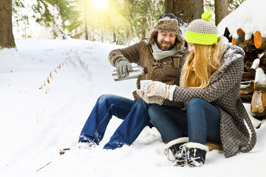 Couple enjoying drink on snowy landscape