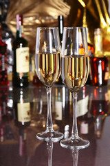 Two Glass of wine, brandy or cognac on the mirror wooden table