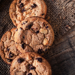 Chocolate cookies on dark  napkin on wooden table. Closeup of a group of assorted cookies..