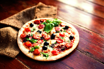 Delicious hot  pizza with salami, pepperoni and cheese on a dark background. Top view  Pizza circle  on  black table..