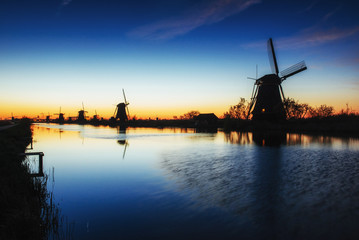Fototapeta na wymiar Fantastic sunset traditional Dutch windmills canal in Rotterdam.
