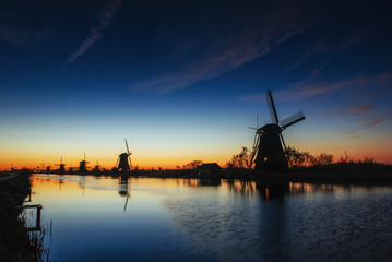 Colorful spring sunset traditional Dutch windmills canal in Rott
