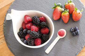 A bowl of delicious and fresh berries: raspberries, blueberries and blackberries