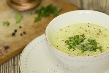Kremowa zupa z czosnku, fasolki i cukinii w białej misce