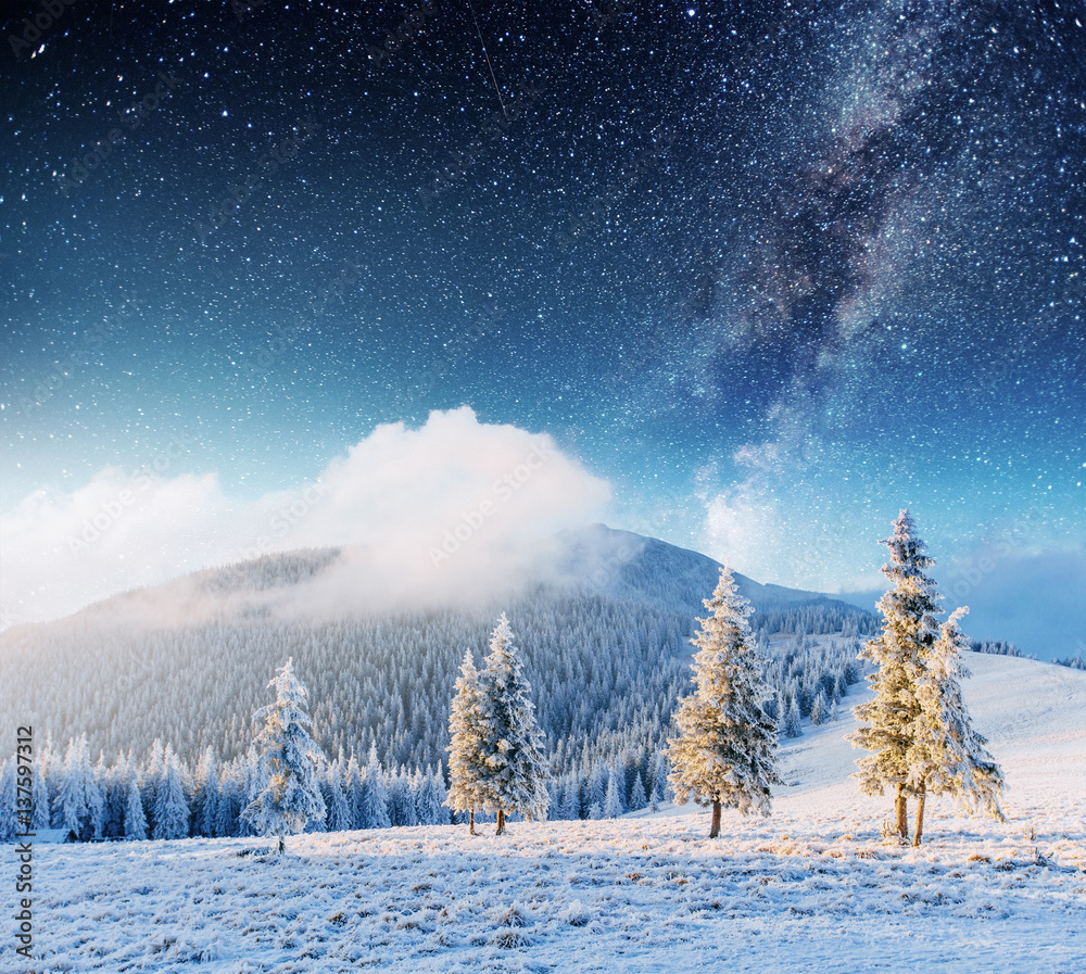 Wall mural fantastic winter meteor shower and the snow-capped mountains