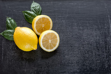 Fresh lemons on the dark wooden background