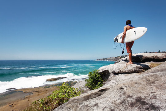 Australian surfer check the waves  on Bondi to Bronte walk in Sydney.