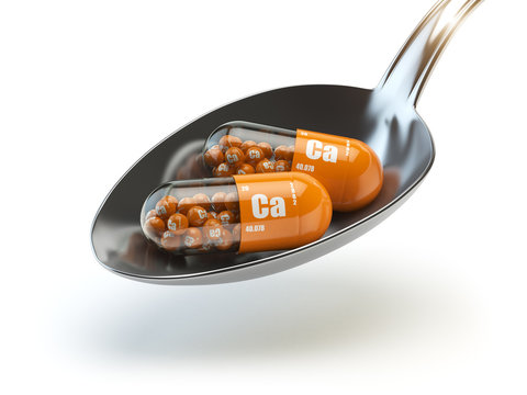Pills With Calcio Calcium CA Element In The Spoon. Dietary Supplements. Vitamin Capsules.