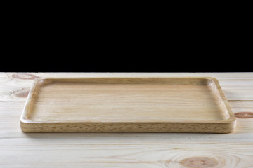 Empty wooden plate on wood table isolated on black