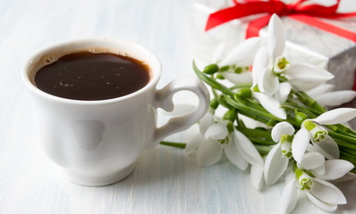 Obraz na płótnie Canvas Coffee with snowdrops flowers and a gift box