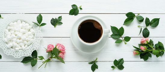 Flat lay still life with roses, coffee and marshmallows  on a white wooden background. women's day. 8 march