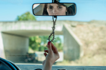 Mujer con mirada en espejo de coche