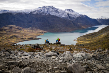 Two hikers taking a rest at fjord, Norway, Europe