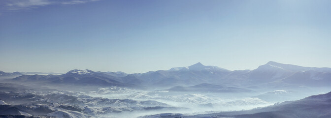 Snowy mountains peaks with mist at sunny day. Carpathian