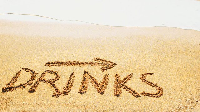 Inscription Drinks and the arrow drawn on the beach sand