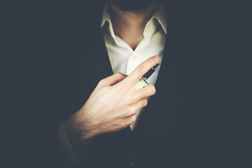 Handsome young businessman using perfume