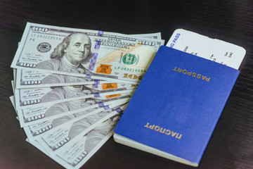 Top view of passport with dollar banknotes on wooden desktop