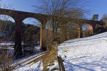 viaduct in winter landscape on a sunny day with blue sky