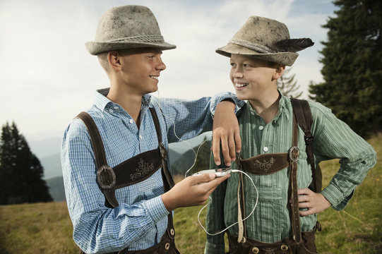 Germany, Bavaria, Two boys in traditional clothing using smart phone