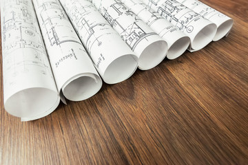 Architect workplace. Architectural project, blueprints, blueprint rolls on wooden desk table....