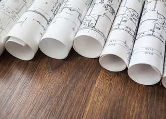 Architect workplace. Architectural project, blueprints, blueprint rolls on wooden desk table....