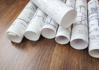 Architect workplace. Architectural project, blueprints, blueprint rolls on wooden desk table....