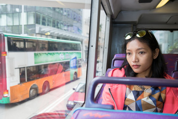 woman in a bus looking out the window at traffic in city © milkovasa