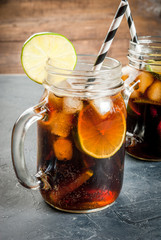 Cocktail Cuba Libre (rum, cola, lime and ice) in mason jar copy space