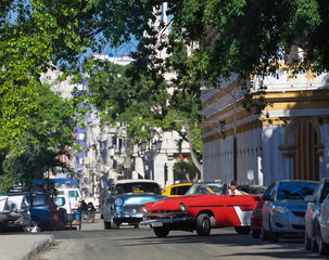 Amerikanischer roter Oldtimer fährt in den Seitenstraßen von Havanna Kuba - Serie Kuba Reportage