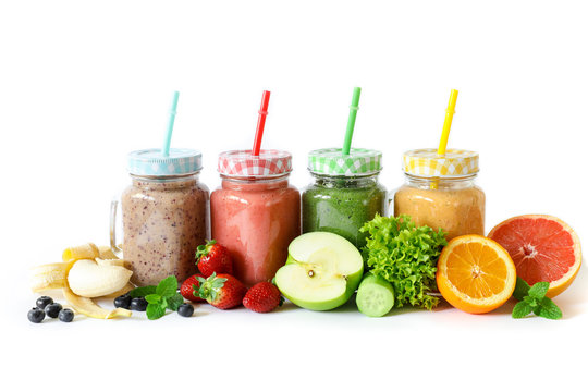 Four different smoothies in a glass jars and ingredients.