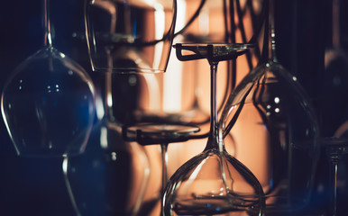 Abstract wine glasses in the dark, close-up view. Conceptual bar design. Illuminated bar counter.