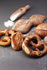 Different kinds of bread and bread rolls on board from above. Kitchen or bakery poster design.