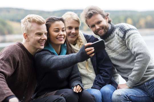 Friends Taking Selfie With Smartphone At Campsite