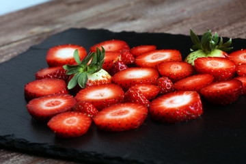 Fresh strawberries array heart shape on old wooden background